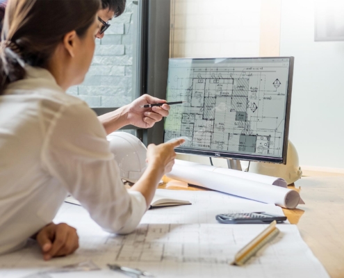 Two engineers looking at floorplans on computer